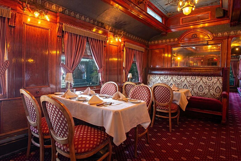 Train car dining room with view of set tables and booth seating